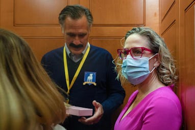 US Senator Kyrsten Sinema (R), D-AZ, rides the elevator with US Senator Mitt Romney (C), R-UT, who i...