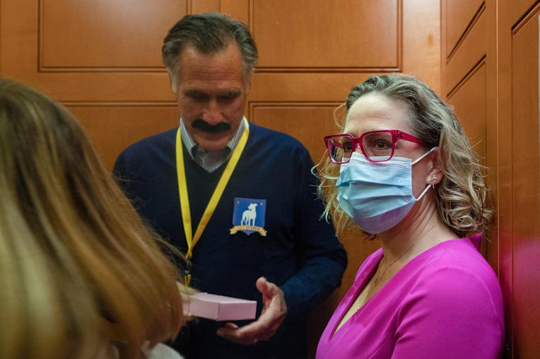 US Senator Kyrsten Sinema (R), D-AZ, rides the elevator with US Senator Mitt Romney (C), R-UT, who i...