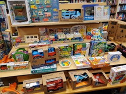 Photo of toy store display shelves packed with toddler toys, from toy vehicles to puzzles. 