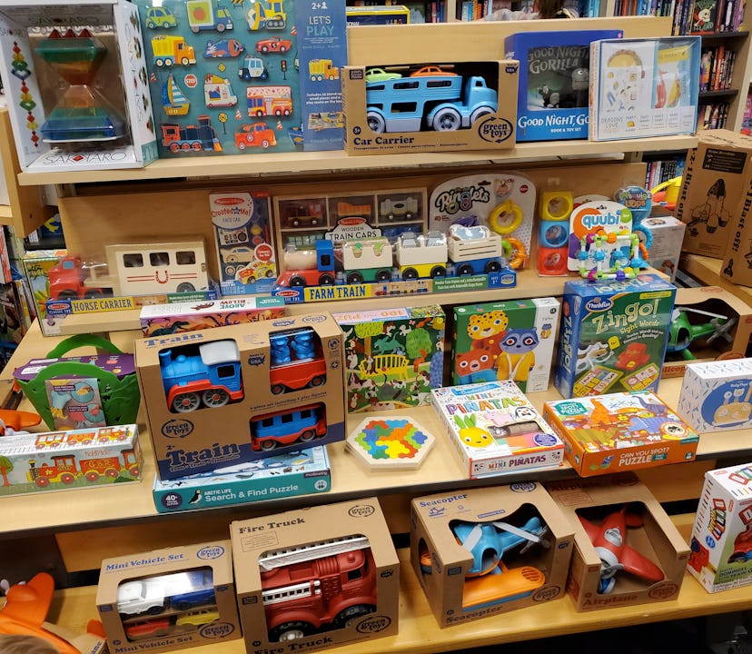 Photo of toy store display shelves packed with toddler toys, from toy vehicles to puzzles.