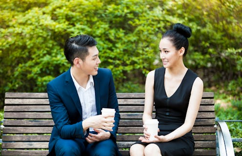 Two office colleagues are having a date outdoors in a park drinking coffee but it seems to be not th...