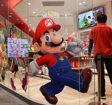 TOKYO, JAPAN - 2021/03/03: An employee stands next to a Super Mario decoration sticker inside Ninten...