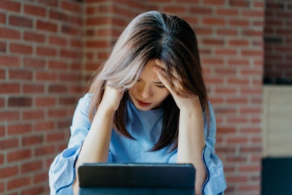 Image of a young asian businesswoman stressed at work and feeling exhausted.