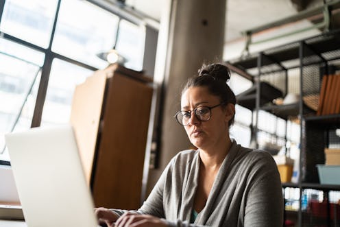 Mature woman working using laptop at work