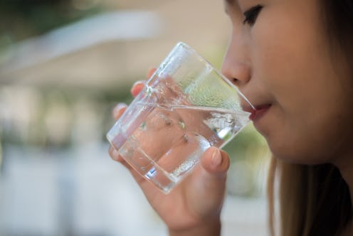 Woman drinking from a glass of water. Drink water for Healthy.