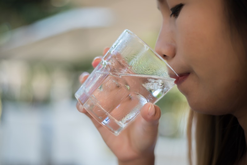 Woman drinking from a glass of water. Drink water for Healthy.