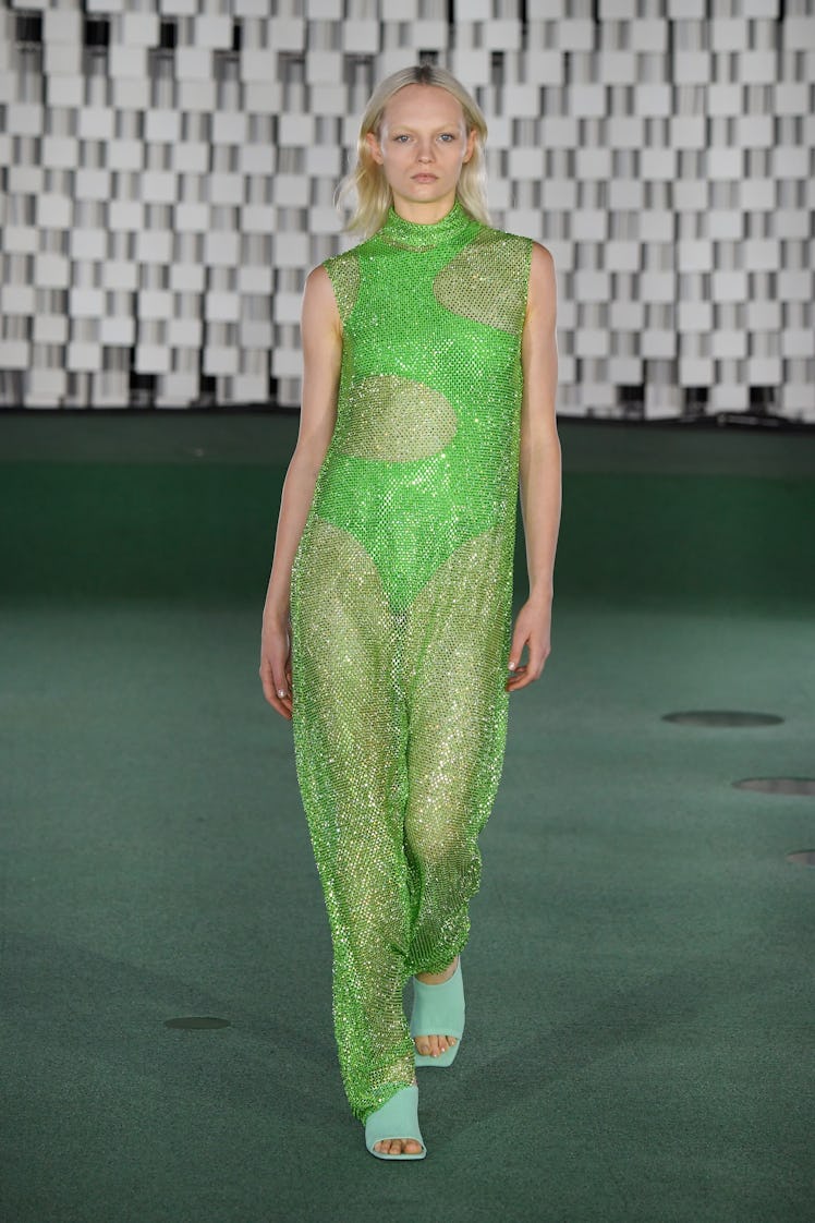 A model walking in an iridescent green dress at the Stella McCartney Womenswear Spring/Summer 2022 s...