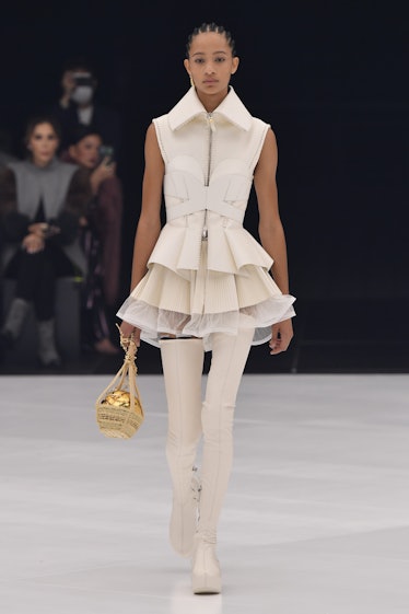 A model walking in a beige dress and boots at the Givenchy Ready to Wear Spring/Summer 2022 fashion ...