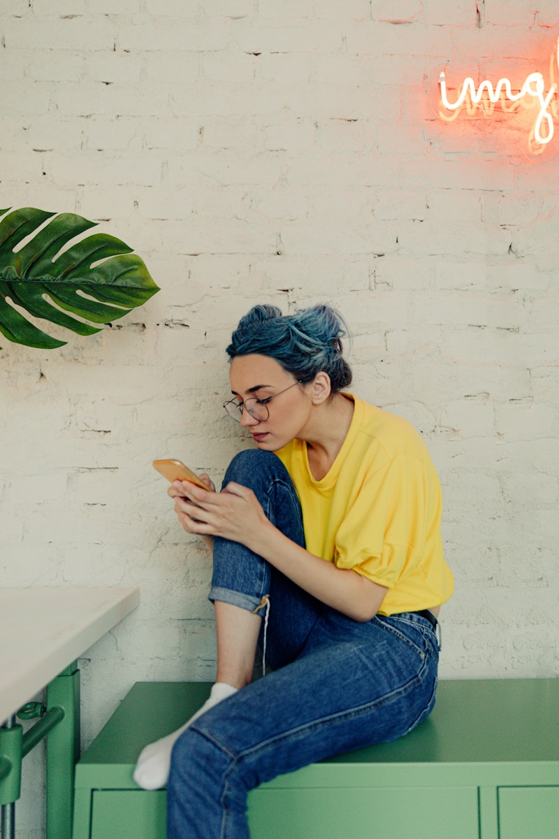 A woman with blue hair refreshes Instagram to see why Instagram is down.