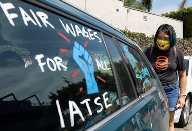 LOS ANGELES, CA - SEPTEMBER 26: Crystal Kan, a storyboard artist, draws pro-labor signs on cars of u...