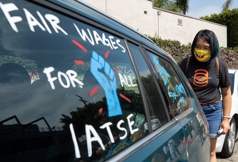 LOS ANGELES, CA - SEPTEMBER 26: Crystal Kan, a storyboard artist, draws pro-labor signs on cars of u...
