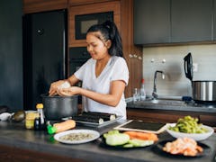 Skilled female sushi chef, making the rice balls for the Nigiri, in her modern domestic kitchen