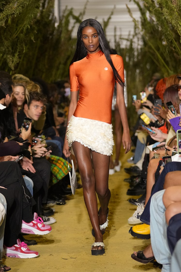 A model walking in an orange-white dress at the Coperni Womenswear Spring/Summer 2022 show