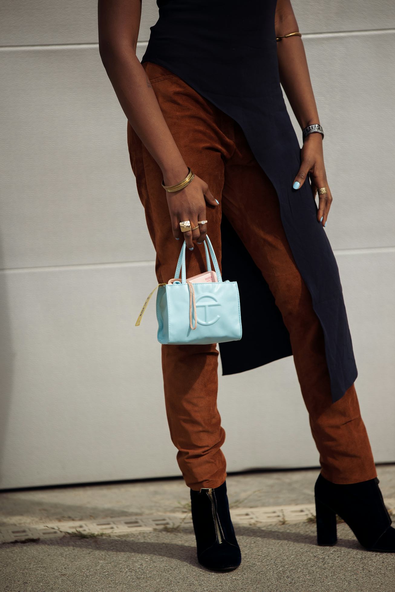 COPENHAGEN, DENMARK - AUGUST 11: Guest wearing brown pants and navy blue long top and light blue bag...