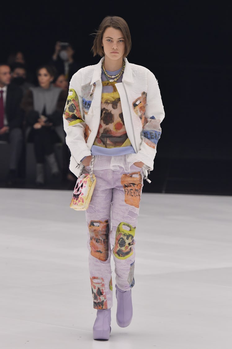 A model walking in a white jacket and lavender pants at the Givenchy Ready to Wear Spring/Summer 202...