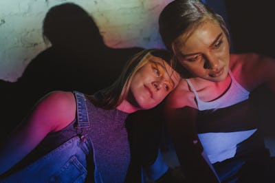 two friends photographed lit under neon lights as they discuss jupiter retrograde ending and how it ...