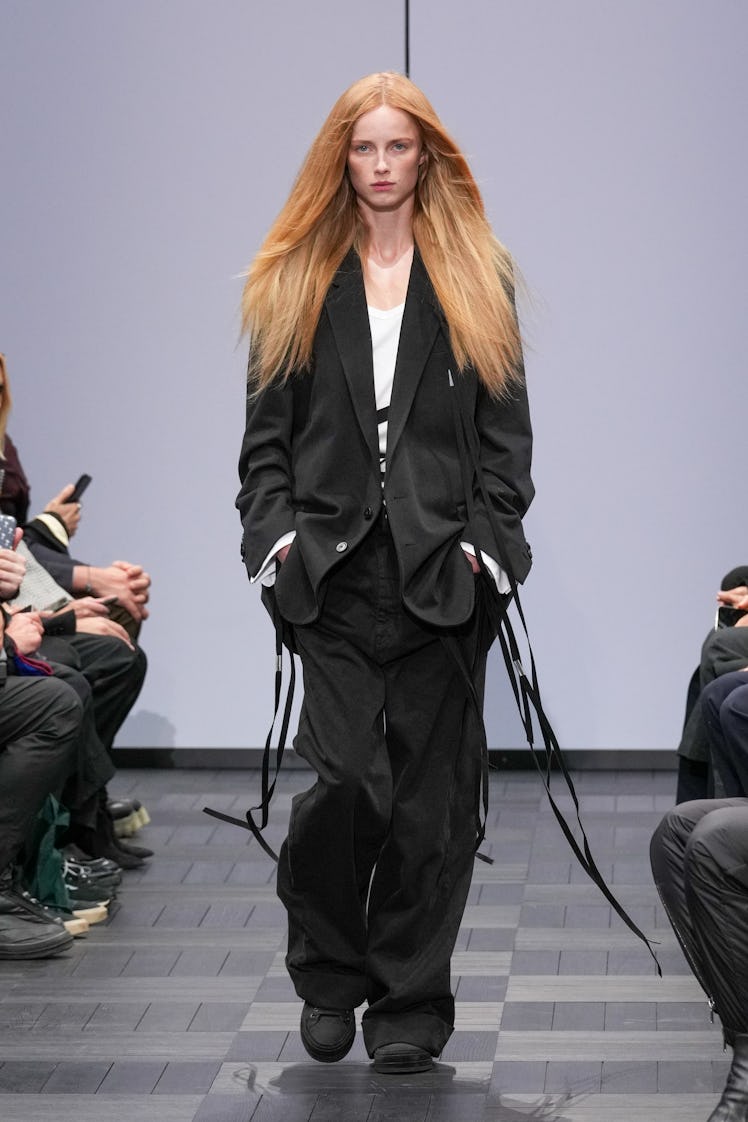 A model walking in a black suit at the Ann Demeulemeester Ready to Wear Spring/Summer 2022 fashion s...