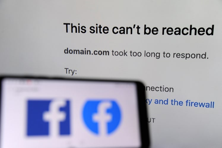 The Facebook logo displayed on a smartphone with a screen showing that Facebook service is down in t...