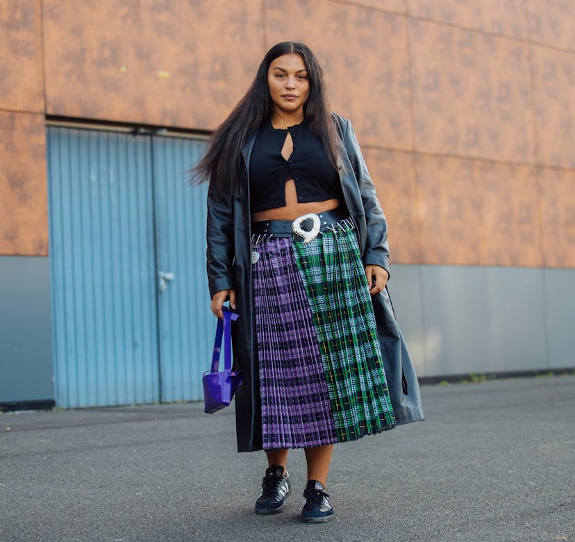 PARIS, FRANCE - SEPTEMBER 30: Model Paloma Elsesser wears a black trench coat, black croptop, green ...