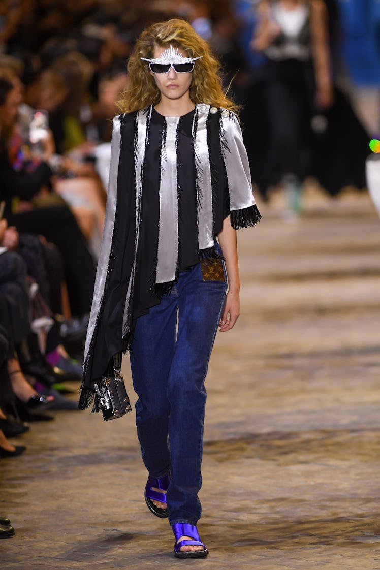 A model walking in a white-black top and blue pants at the Louis Vuitton Womenswear Spring/Summer 20...