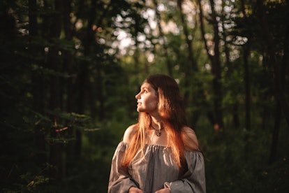 young woman in forest reflecting on november 2021 being the best day for her zodiac sign