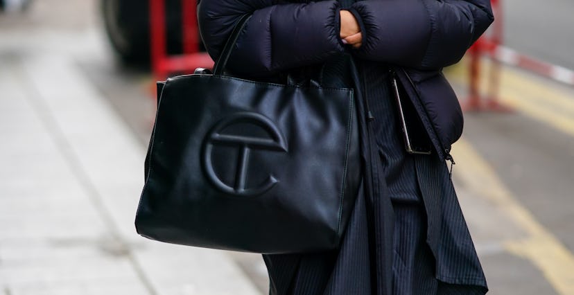PARIS, FRANCE - OCTOBER 04: A guest wears a black puffer long winter coat, a black leather Telfar ba...