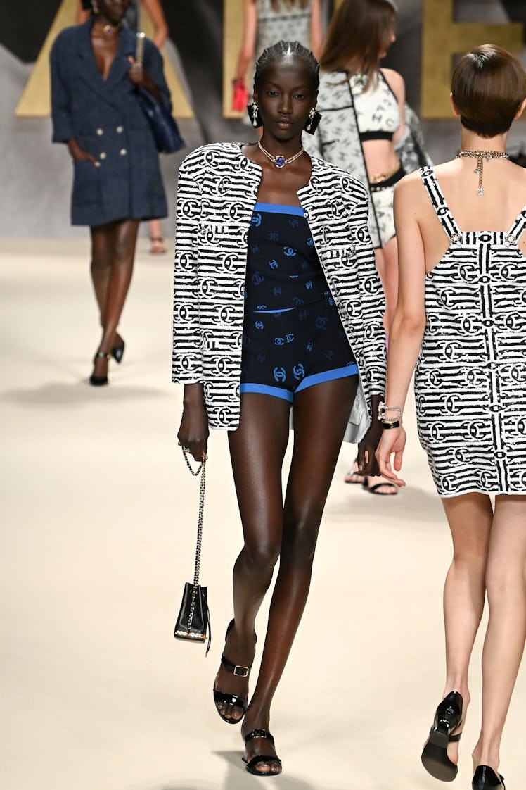 A model walks in a black-blue romper and black-white blazer at the Chanel Womenswear Spring/Summer 2...