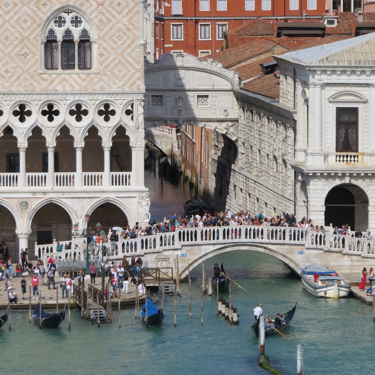 September 20, 2019 - Venice, Italy: Gondolas pass under a bridge where tourists are gathered to take...