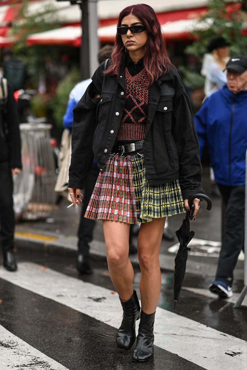 PARIS, FRANCE - OCTOBER 03: A guest is seen wearing a black jacket, knit top and plaid skirtoutside ...