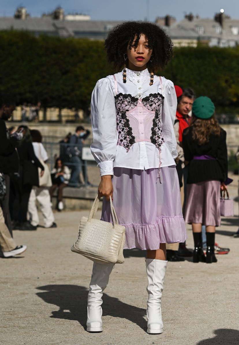 PARIS, FRANCE - SEPTEMBER 28: A guest is seen wearing a white blouse, pink corset, pink skirt, white...