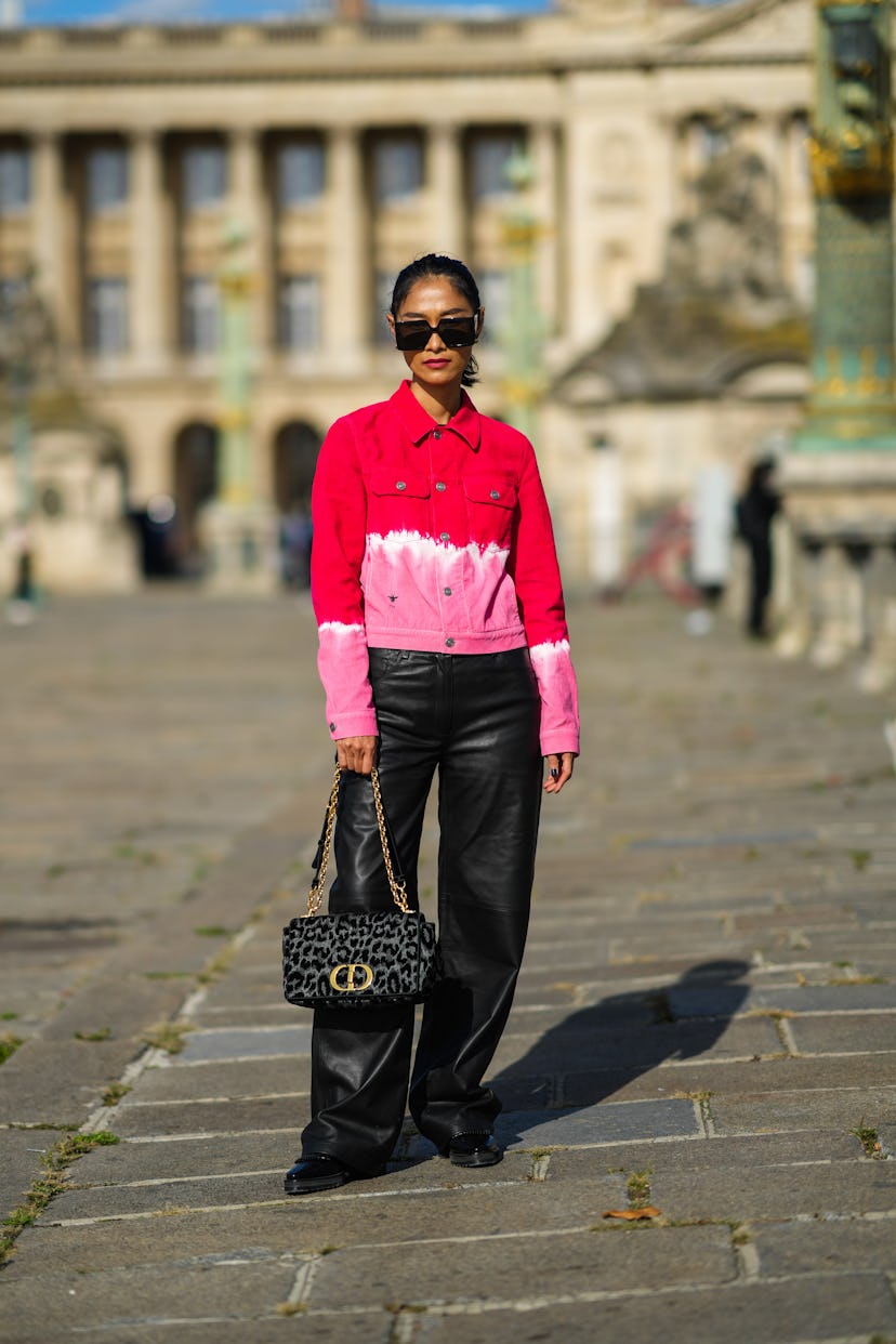 PARIS, FRANCE - SEPTEMBER 28: Pornwika Spiecker wears black sunglasses, gold earrings, a red / white...