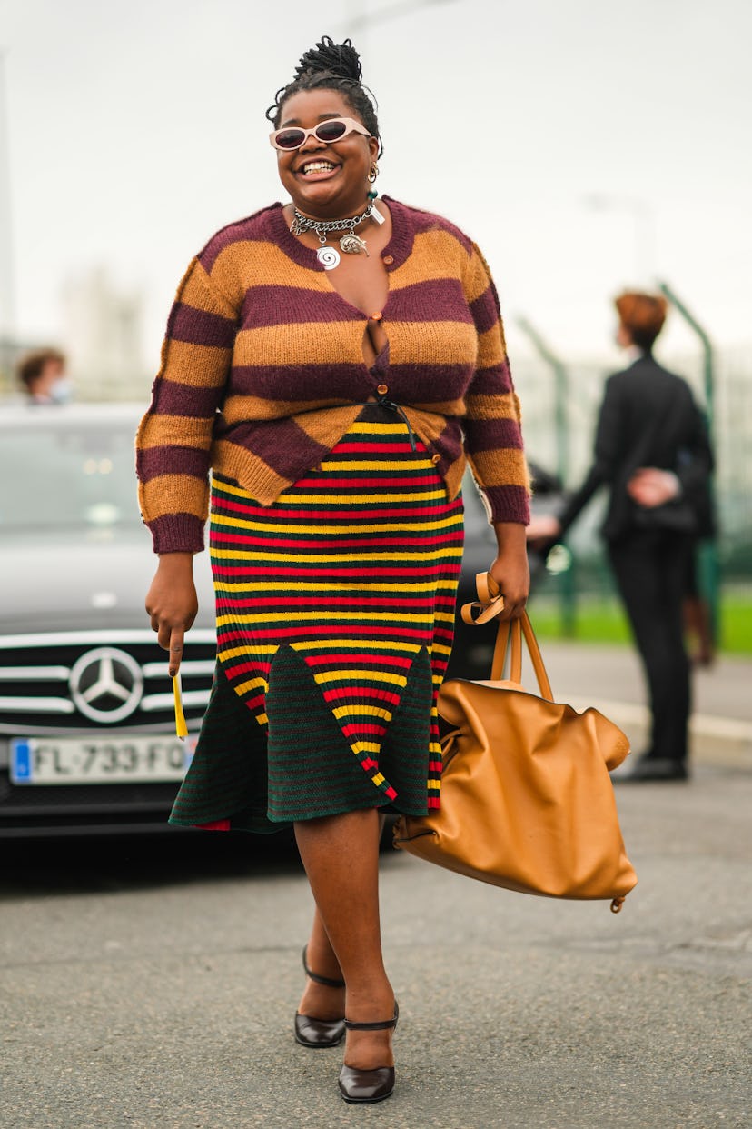 PARIS, FRANCE - OCTOBER 02: Gabriella Karefa-Johnson wears beige sunglasses, gold earrings, a silver...