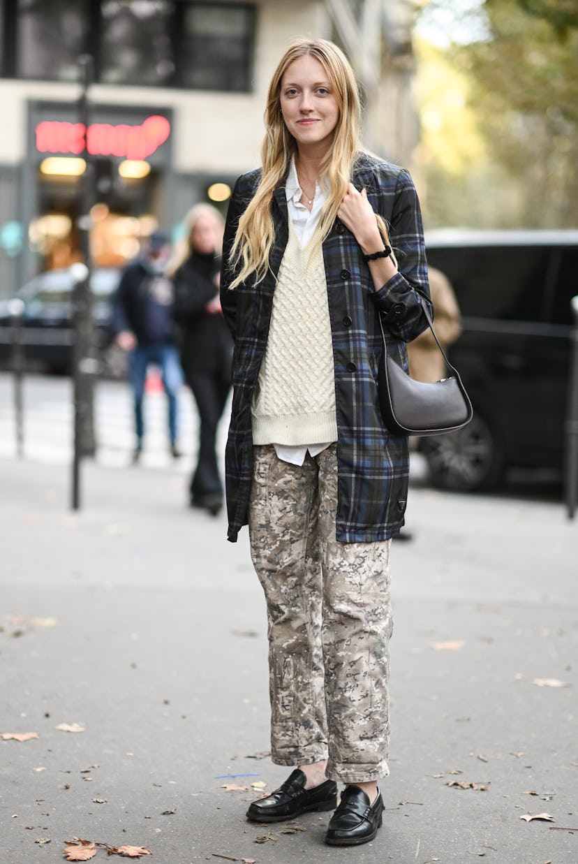 PARIS, FRANCE - OCTOBER 03: A guest is seen wearing a plaid jacket, cream sweater and camo pants out...