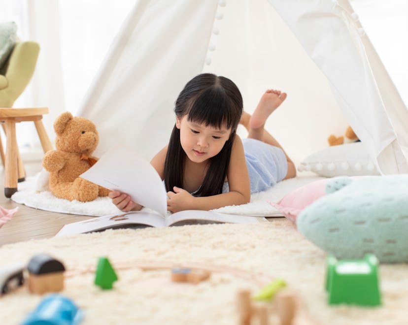 young girl reading book at home 