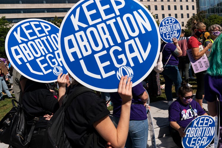 Women rights activists and advocates for abortion rights hold up signs as they gather at Freedom Pla...