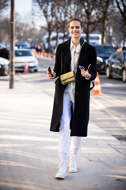 A high-top sneaker outfit with white jeans, a shirt, and a coat.