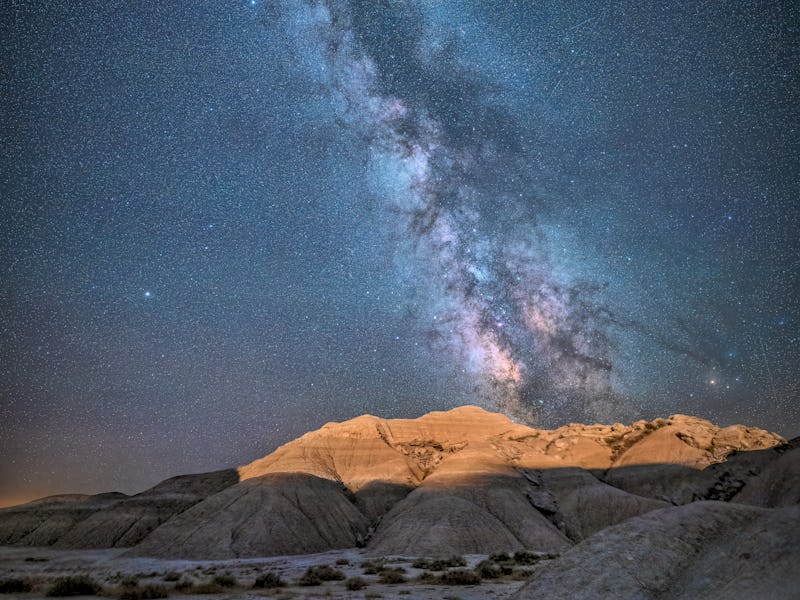 The lights from the train that runs through the Oglala National Grassland light up the badlands of T...