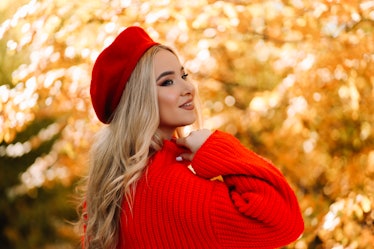 Young woman wearing red sweater and beret during November, best month for her zodiac sign.