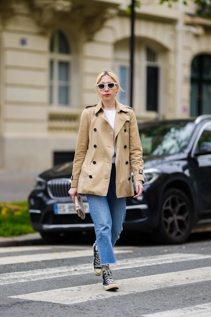 A high-top sneaker outfit with jeans, a white T-shirt, and a trench coat.