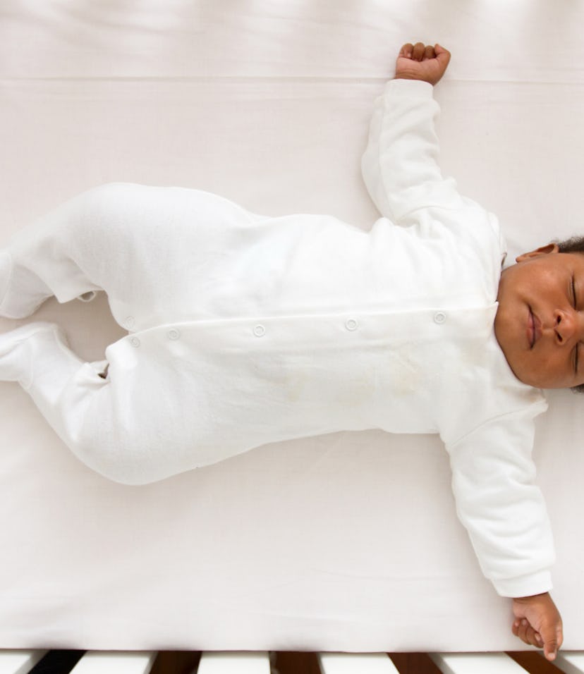 Baby sleeping on its back in a crib