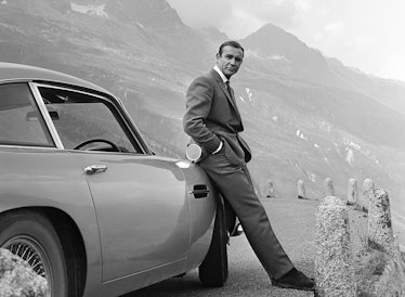 1964:  Actor Sean Connery poses as James Bond next to his Aston Martin DB5 in a scene from the Unite...