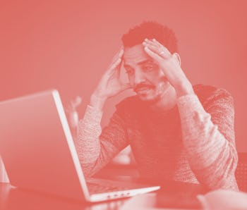 Worried or tired man working using laptop at home