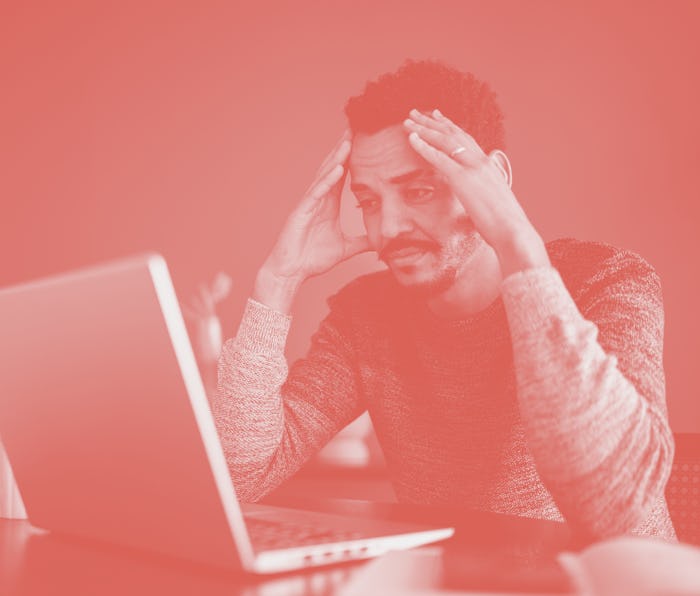 Worried or tired man working using laptop at home