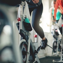 Cropped shot of women working out with exercise bikes in a exercising class at the gym