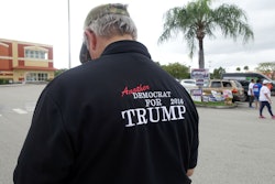 A man wearing a shirt that reads Another Democrat for Trump 2016 stands outside a Miami library poll...