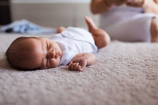 Adorable young baby resting on the bed in a nursery