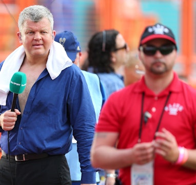 Adrian Chiles of ITV Sport unbuttons is shirt and walks around with a towel around his neck before b...
