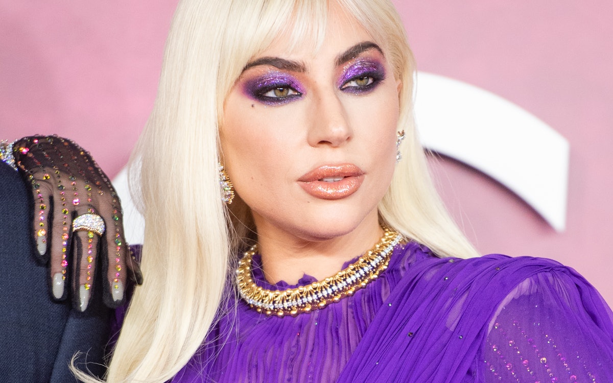 Lady Gaga at the House Of Gucci UK premiere wearing new bangs and metallic purple makeup, all by her...