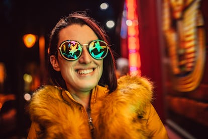 Young Caucasian beautiful woman and neon light on street.