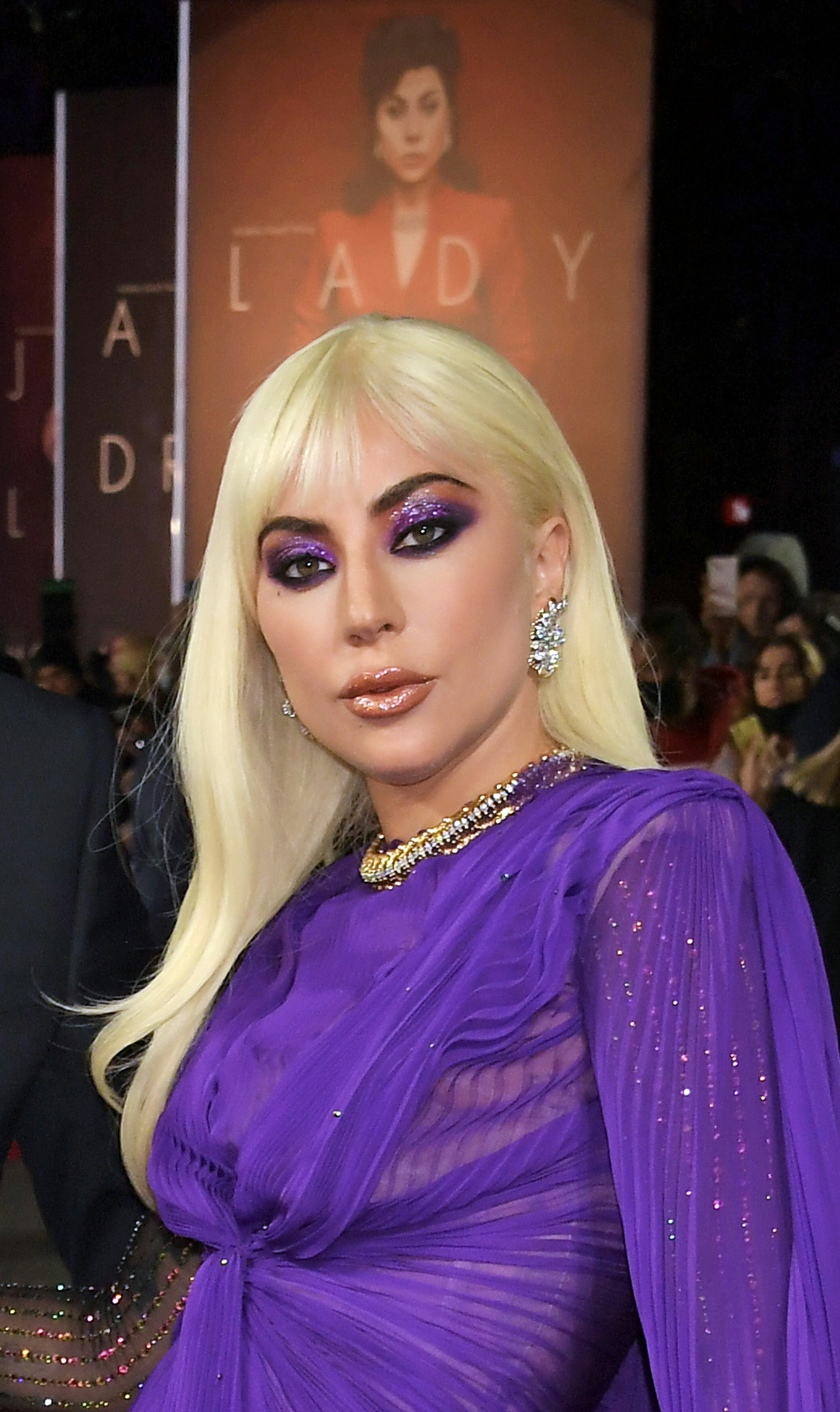 Lady Gaga at the House Of Gucci UK premiere wearing new bangs and metallic purple makeup, all by her...